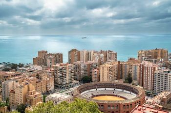 Aerial view of Malaga: residential blocks, the bullring and the sea